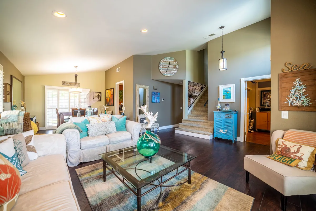Living room with deep forest green accent wall, cream sofa, and warm wood furniture