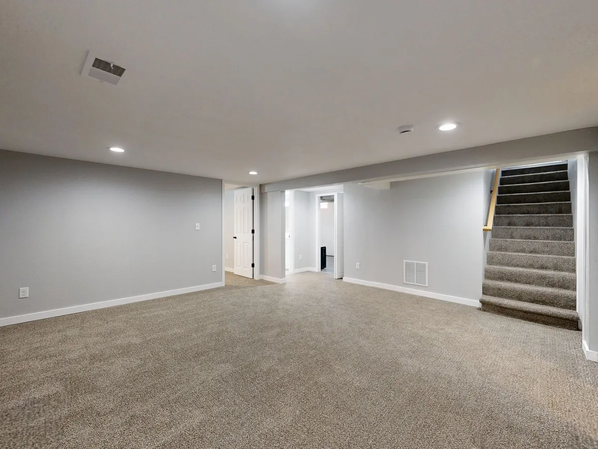 Completed finished basement showing home theater area with comfortable seating, proper lighting, and quality flooring