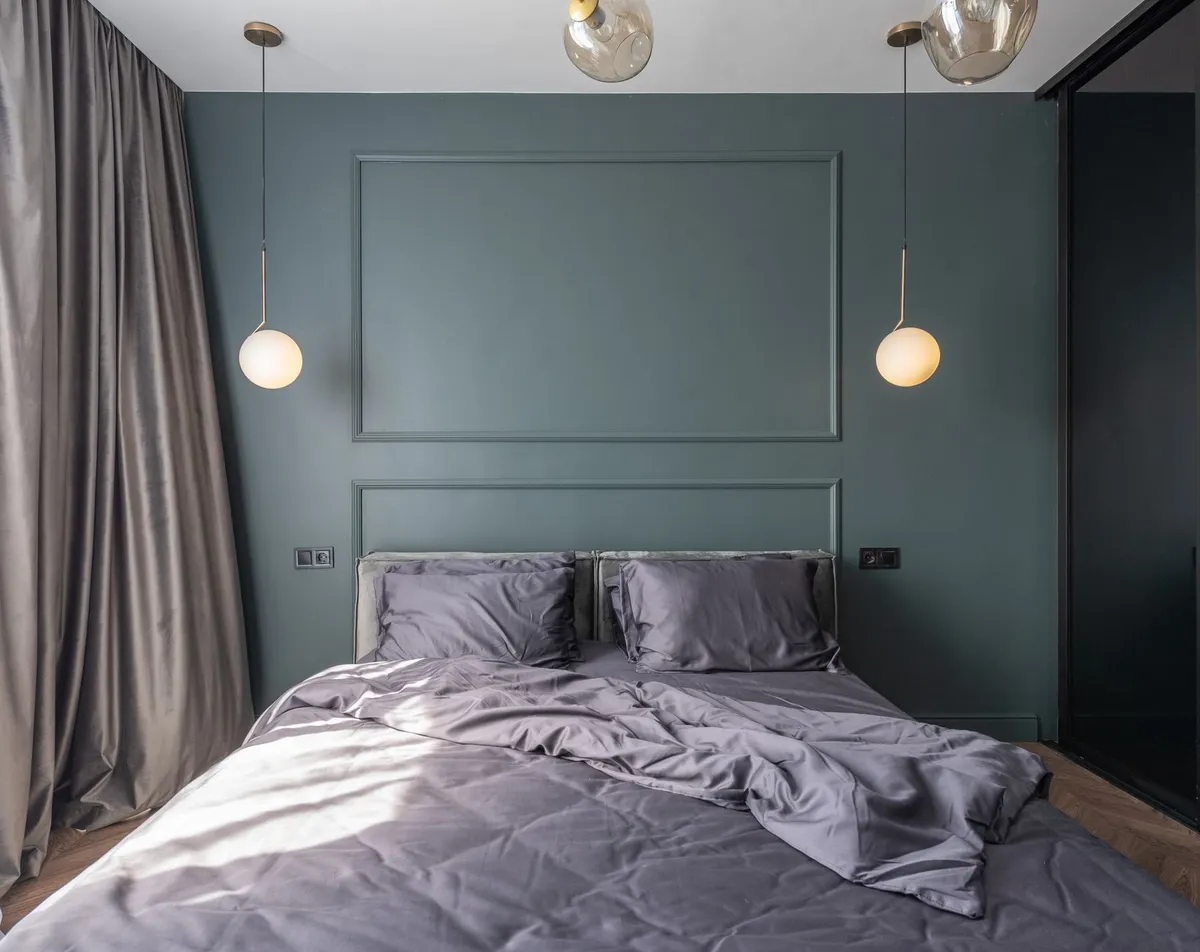 Luxury primary bedroom with built-in storage, pendant lighting, and neutral linen bedding