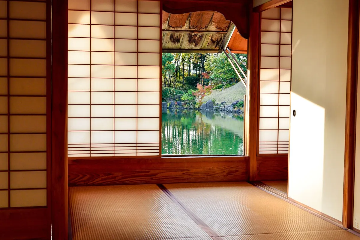 Zen bedroom with natural light through shoji-style screens, linen bedding and simple wooden furniture