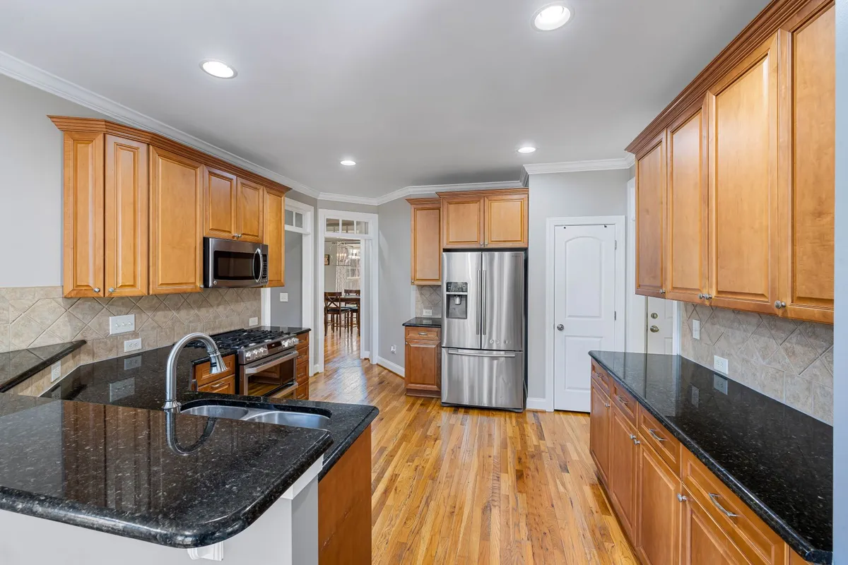 Modern kitchen with white cabinets and quartz countertops showing renovation potential