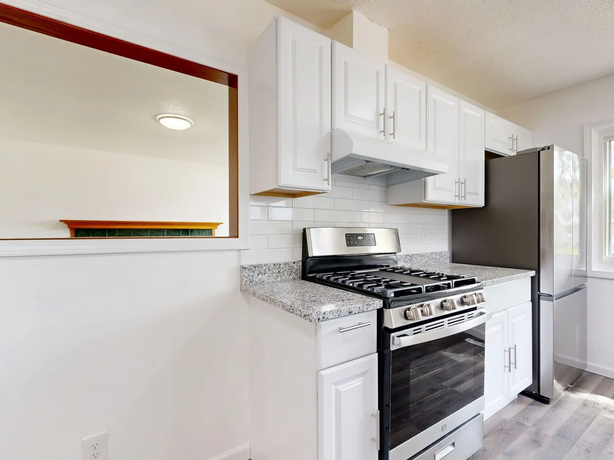 Before and after AI render showing a dated kitchen refreshed with new cabinet color, countertop, and layered lighting